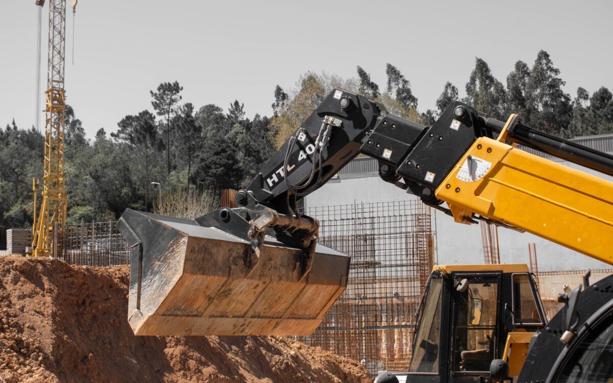 Utah contractors comparing equipment rental options at a modern rental facility with heavy machinery and fleet vehicles