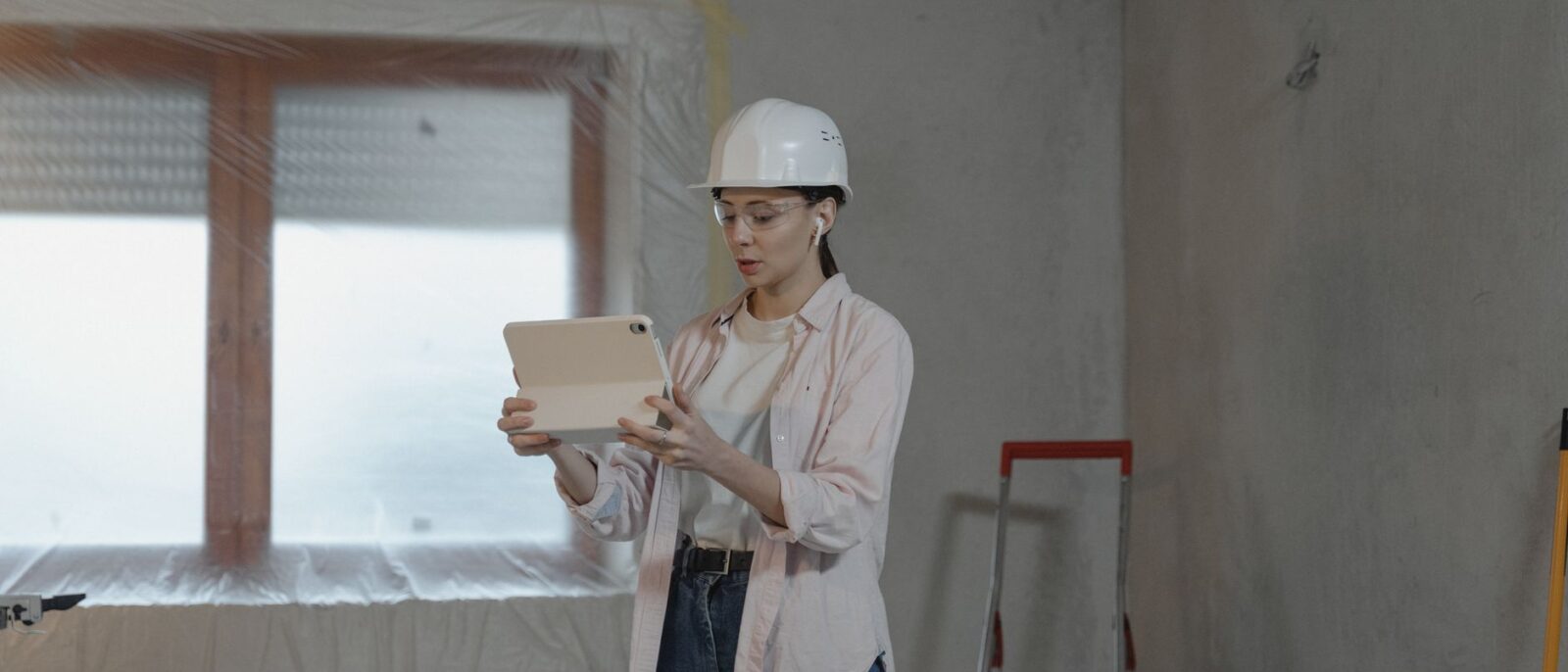 Utah contractor using equipment rental management software on tablet to track costs and reduce downtime on active construction job site