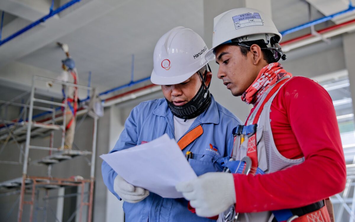 Utah contractor using equipment rental ROI calculator on tablet at construction project site