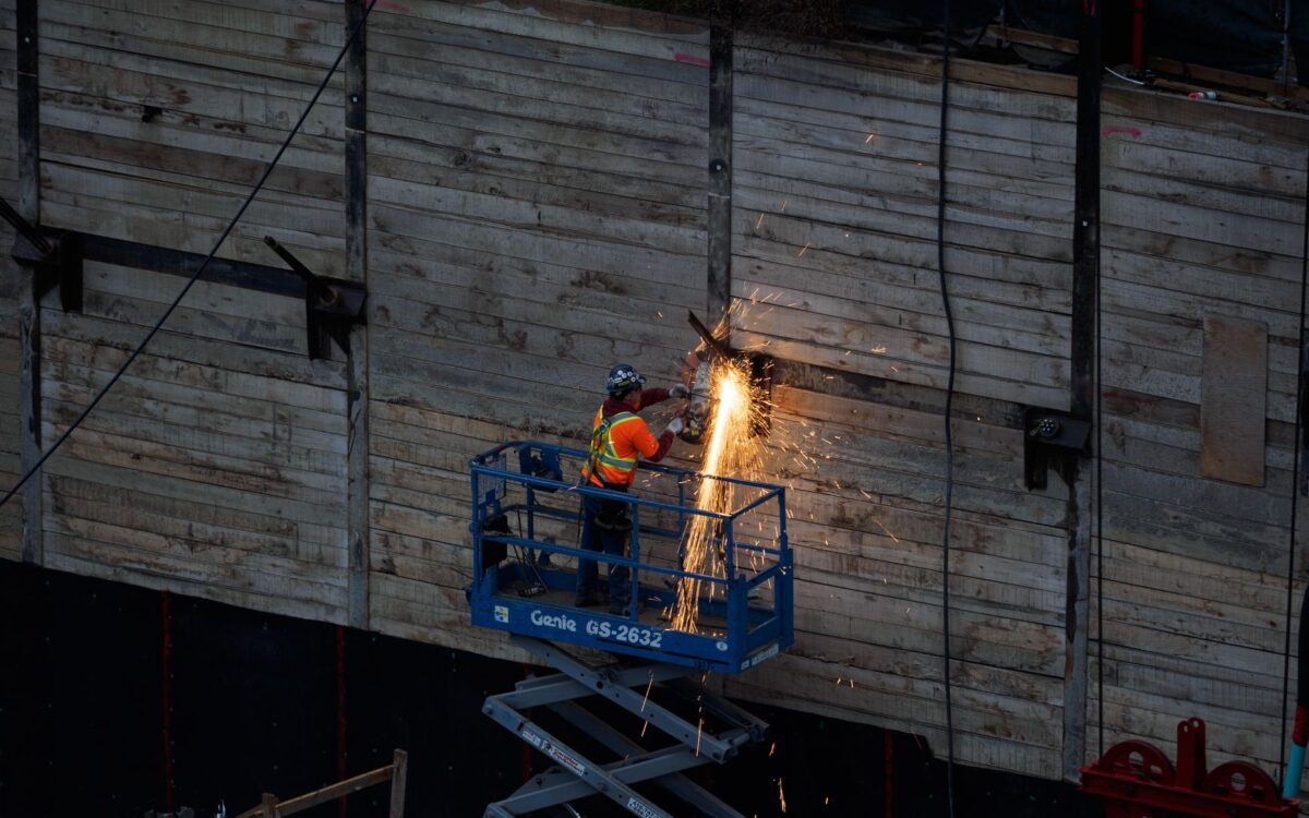 Lift equipment rental availability in Utah cities showing elevated work platform on construction site with urban landscape