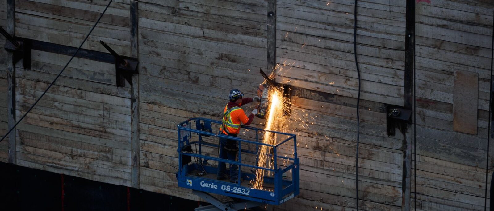 Lift equipment rental availability in Utah cities showing elevated work platform on construction site with urban landscape