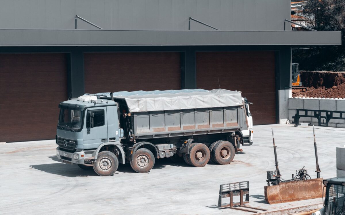 Construction equipment rental dispatch yard in Utah showing delivery trucks and heavy machinery ready for transport