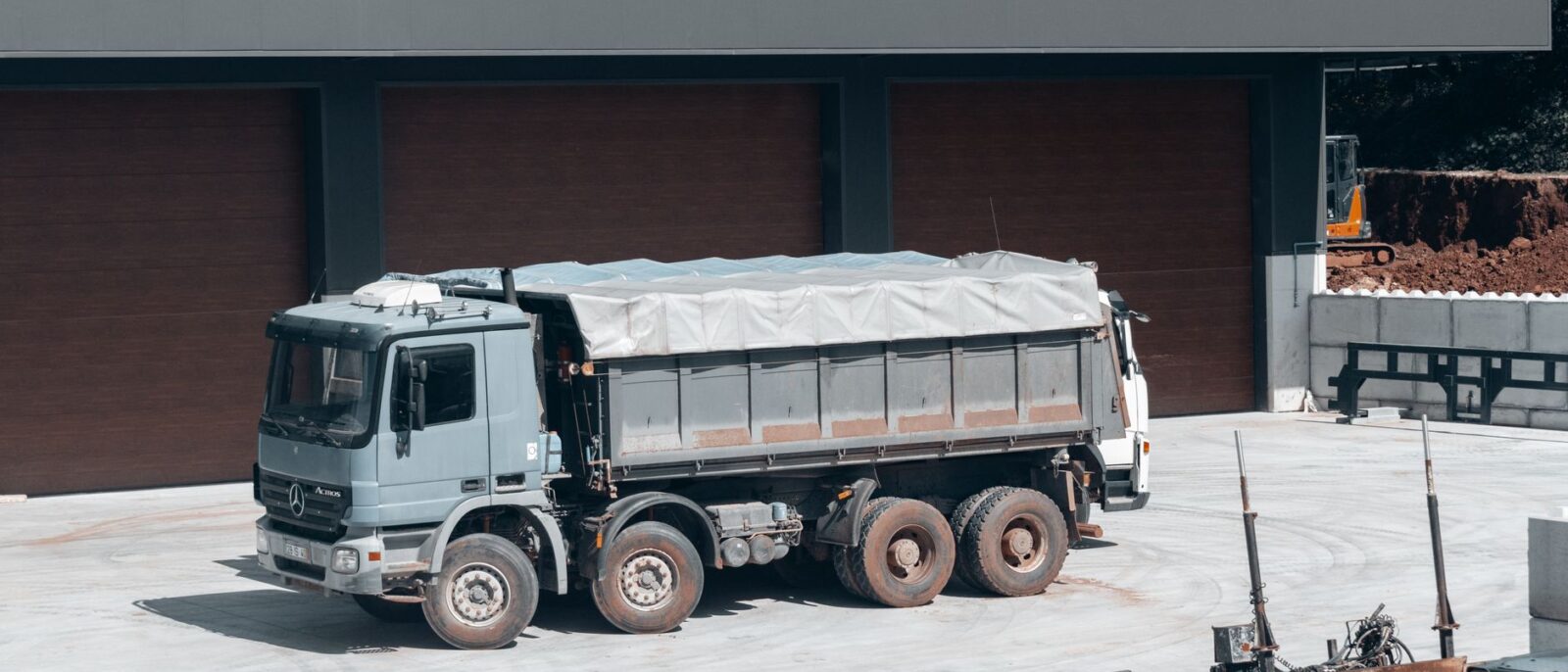 Construction equipment rental dispatch yard in Utah showing delivery trucks and heavy machinery ready for transport