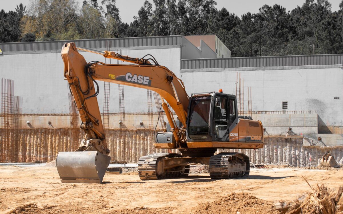 A large excavator positioned at an active construction site with clear skies.
