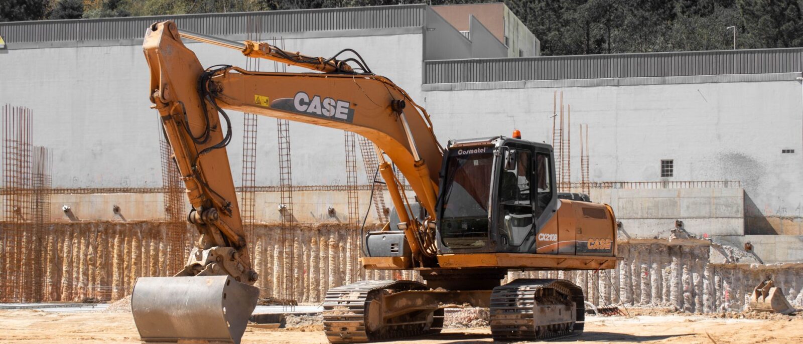 A large excavator positioned at an active construction site with clear skies.