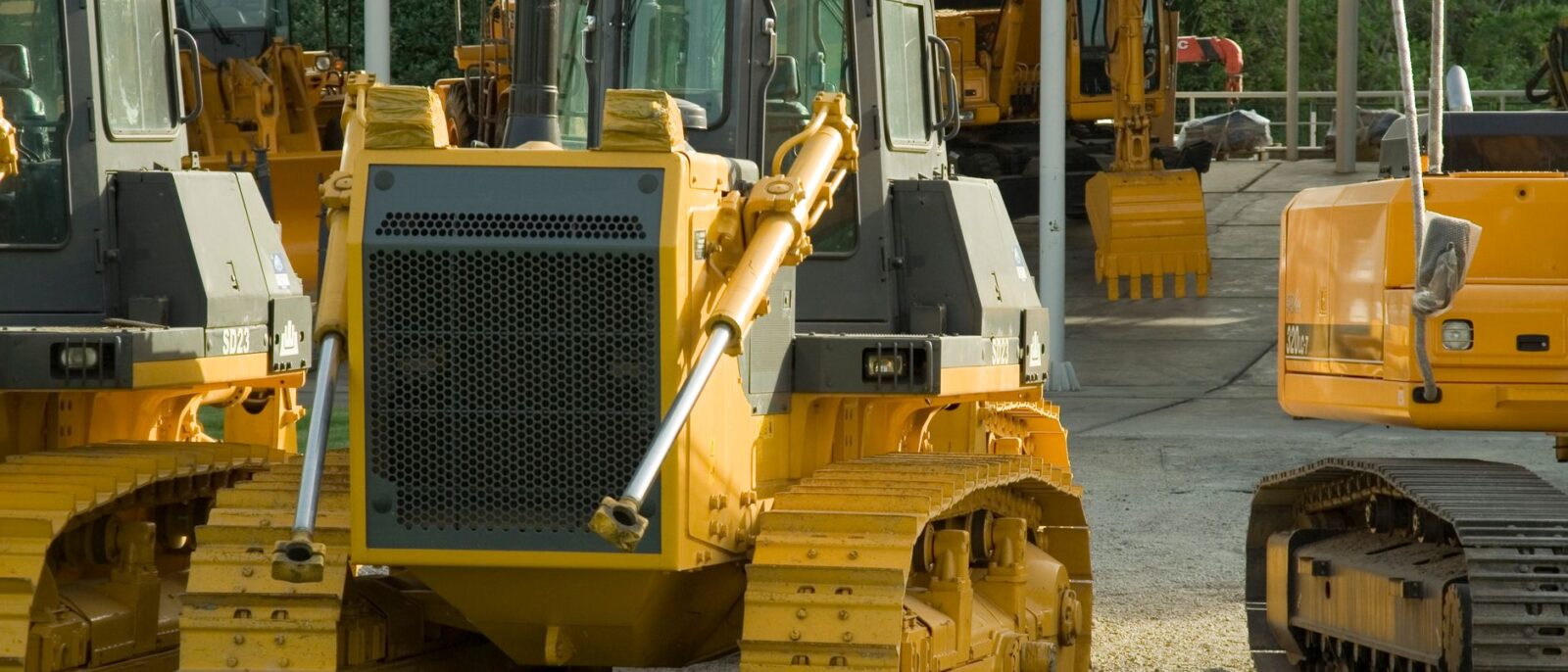 Multiple bulldozers parked in an outdoor construction area, ready for use.