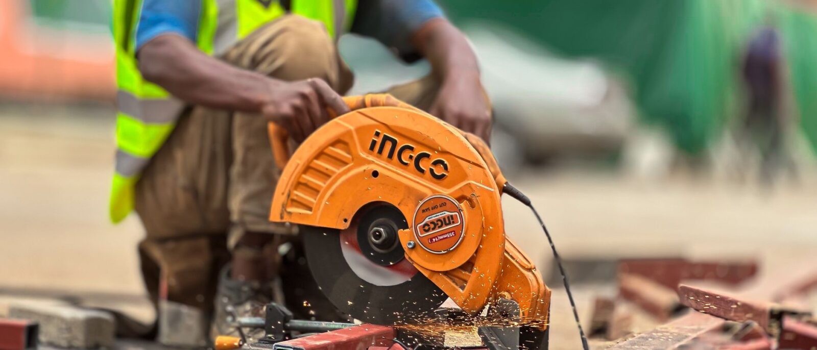Worker using circular saw to cut metal on a construction site.