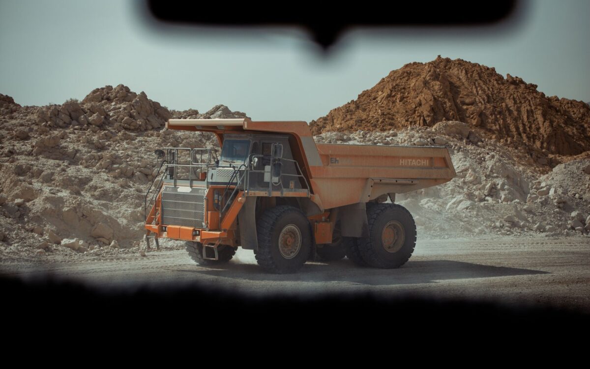 A large dump truck operates in a dusty quarry in Biskra, Algeria.
