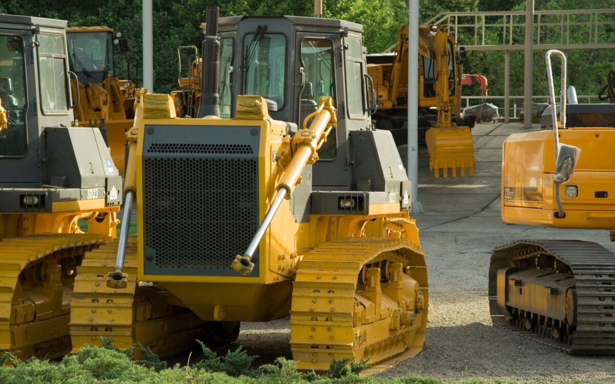 Multiple bulldozers parked in an outdoor construction area, ready for use.