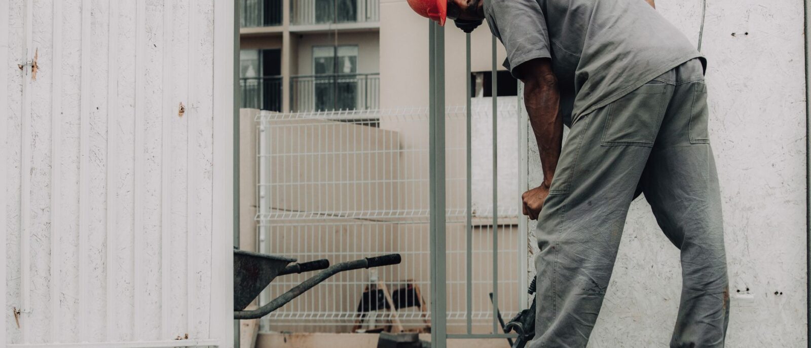 Man in hard hat operating a jackhammer on an outdoor construction site.