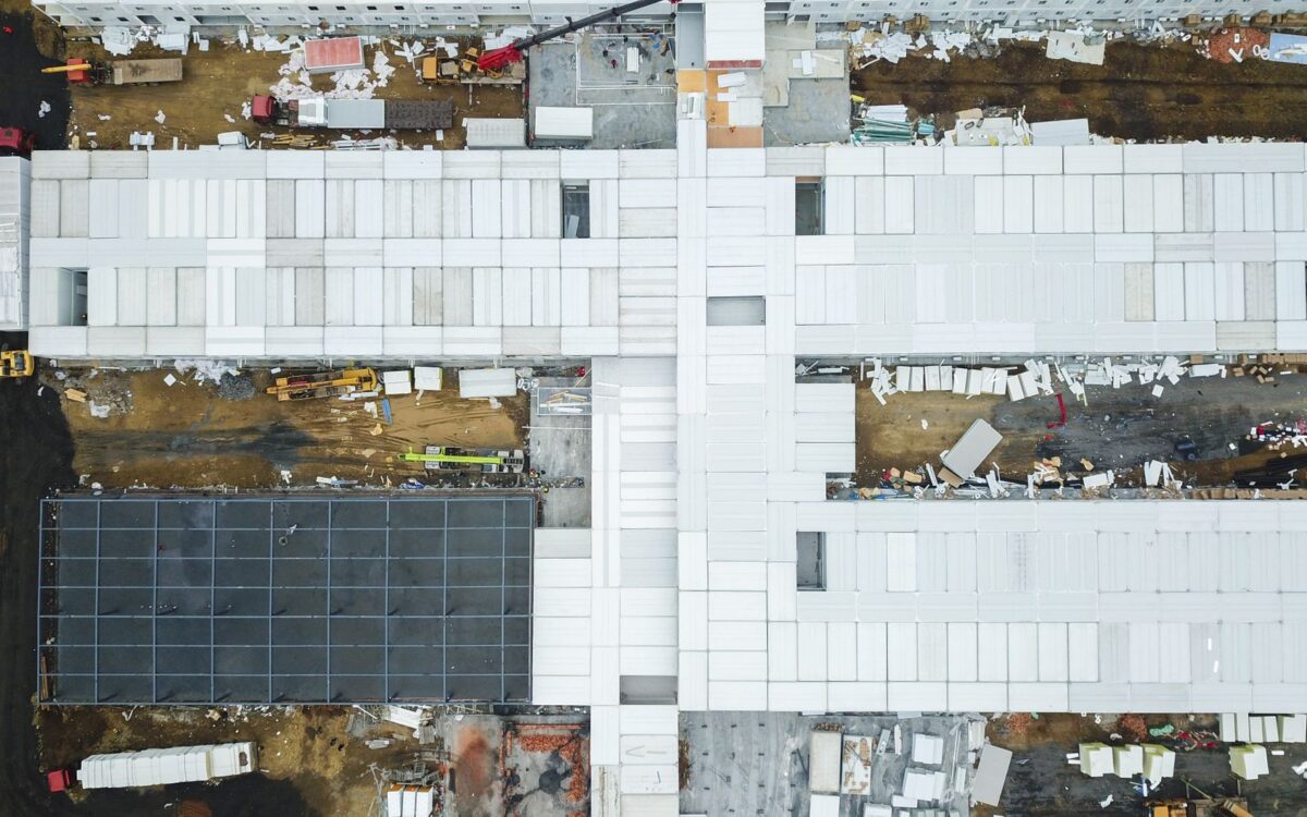 Drone shot capturing aerial view of a large construction site with unfinished buildings.