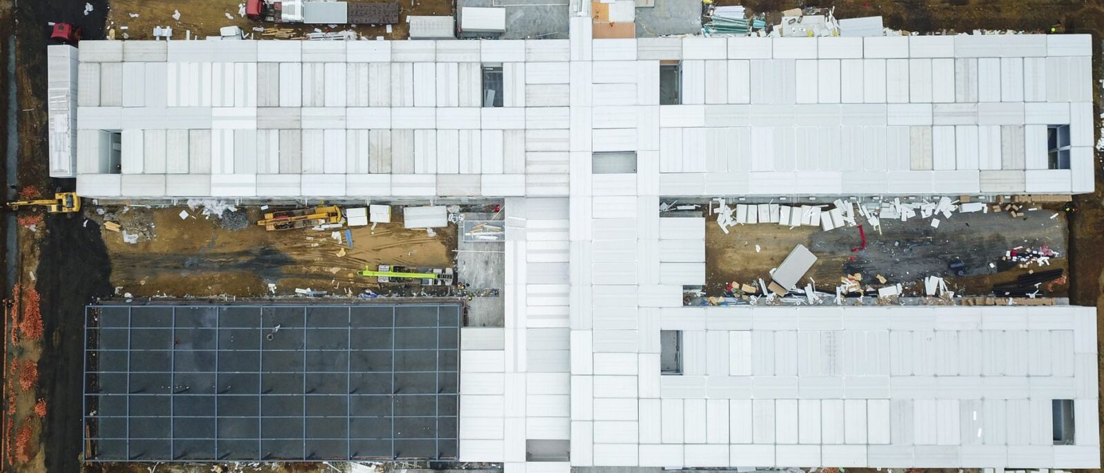 Drone shot capturing aerial view of a large construction site with unfinished buildings.